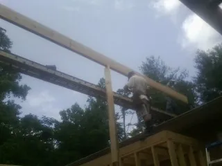 Carpenter setting a ridge beam over a new addition frame — Ice Dam Removal by Roofing Brothers in Bear River City