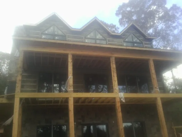 Dormers and porch framing on a large log home under construction — Roof Coating work by our crew in Bear River City