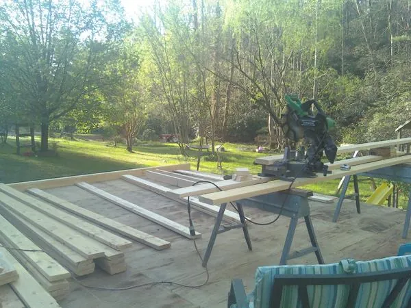Miter saw and framing lumber on a deck under construction in Bear River City