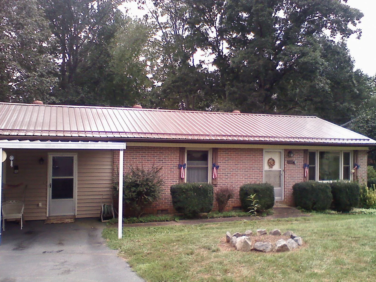 Bronze metal roof and carport on a brick ranch home — Roof Repair work by our crew in Bear River City